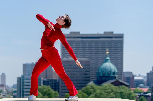 A dancer practicies Brown’s <i>Roof Piece</i> against the Philadelphia skyline.